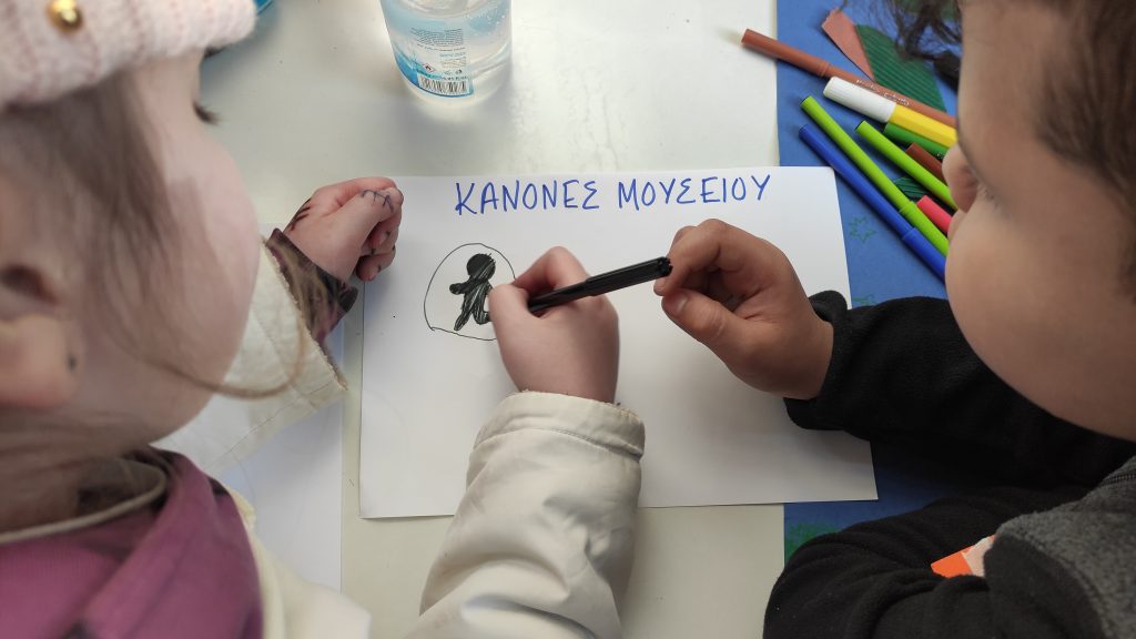 Φωτογραφία παιδιών που γράφουν τους κανόνες του μουσείου για την έκυεση του προγράμματος Παραμύθι Αλλιώς.