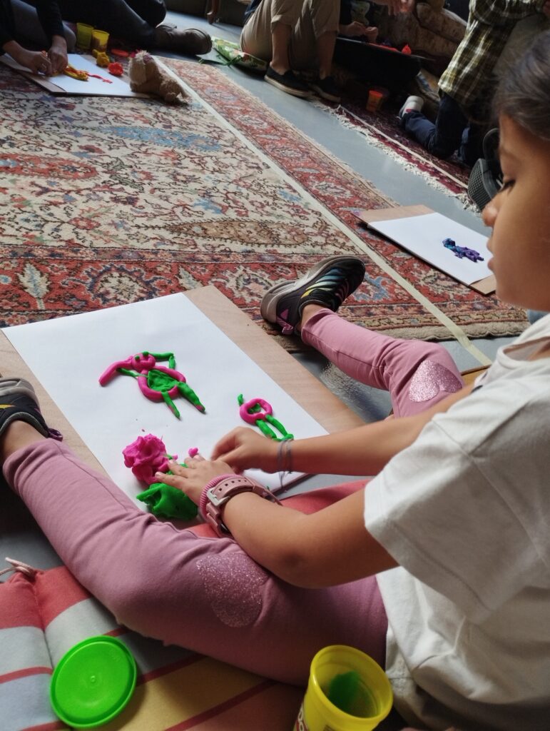 Κορίτσι φτιάχνει κατασκευές με πλαστελίνη πάνω σε χαρτί